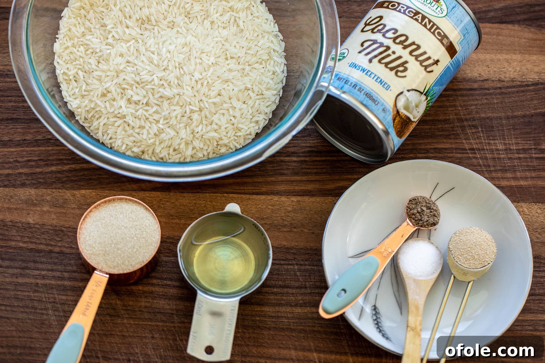 East Africa's Sweet Secret: Vitumbua Coconut Rice Pancakes 3 Ingredients for Vitumbua neatly arranged on a chopping board: rice, coconut milk, sugar, yeast, salt, cardamom, and oil.