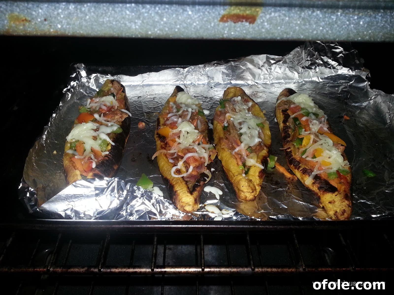Plantain Boats: Unlock Your Creativity with Tropical Flavors 16 Stuffed plantain boats with shredded cheese sprinkled on top, ready for final baking