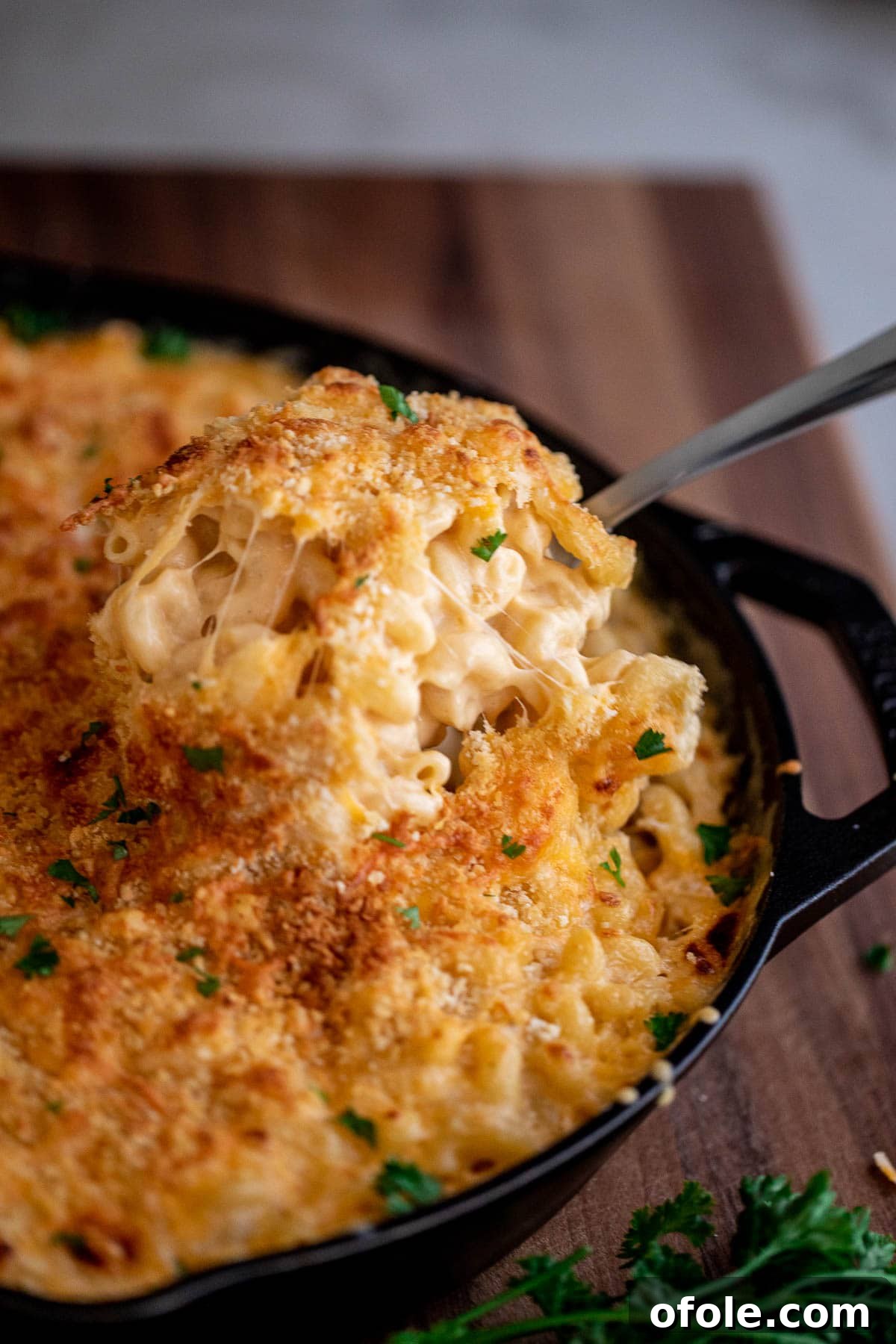 Ultimate Three-Cheese Mac and Cheese 2 Spoon lifting up creamy mac and cheese from a bowl, showcasing its gooey texture