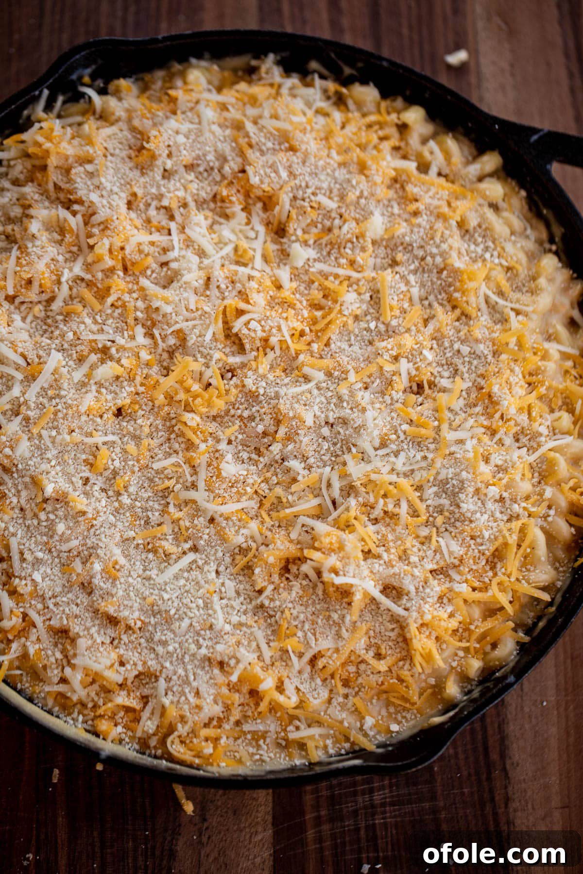 Ultimate Three-Cheese Mac and Cheese 7 Mac and cheese topped with shredded cheese and panko breadcrumbs, ready for baking