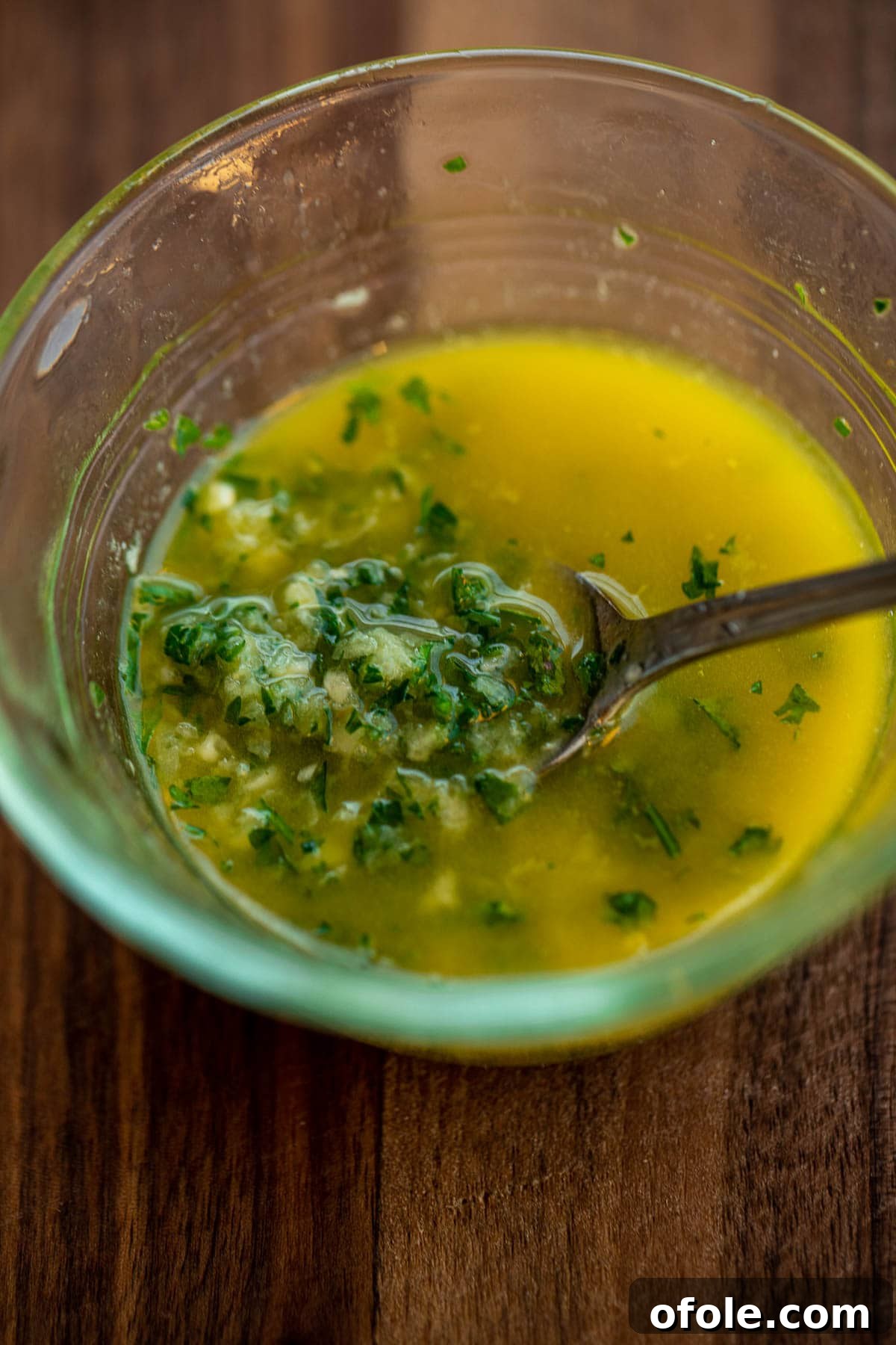 Buttery Garlic Dinner Rolls 11 A small bowl containing melted butter, minced garlic, and fresh parsley, mixed to create the garlic butter topping.