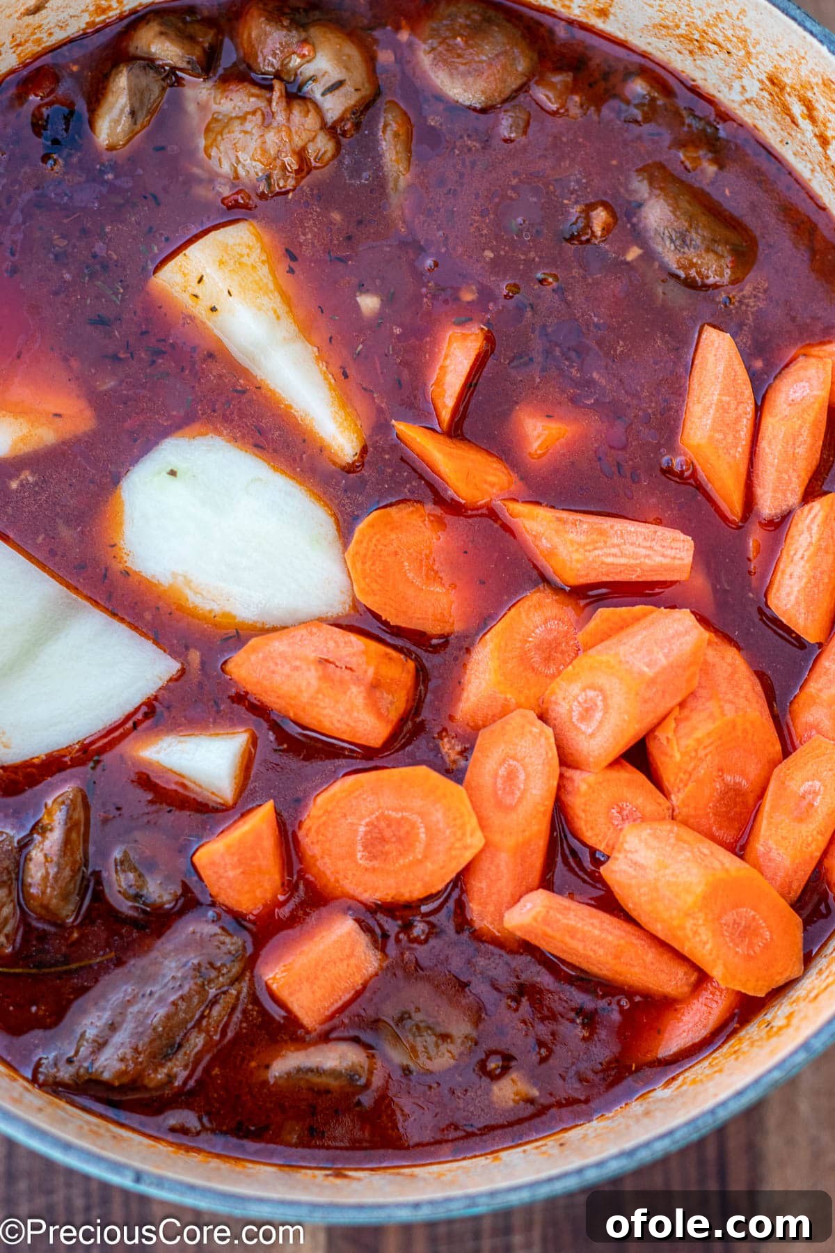 Wine-Free Beef Stew 11 Raw carrots and potatoes freshly added to the simmering pot of stew.