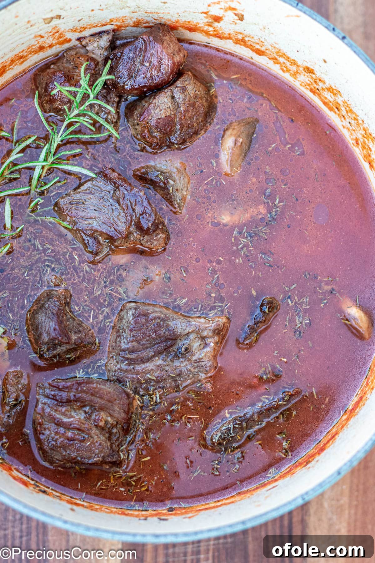 Wine-Free Beef Stew 9 Dutch oven filled with beef, broth, and crushed tomatoes, ready for simmering.