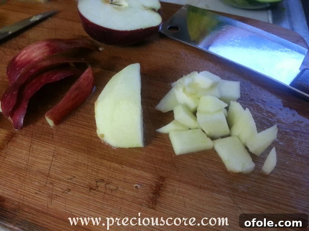 Vibrant Cameroonian Fruit Salad 10 Freshly cut apple pieces, with some skin on, ready to join the fruit mix