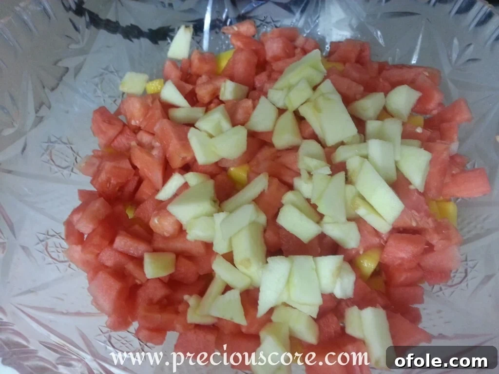 Vibrant Cameroonian Fruit Salad 11 All the prepared fruits - pineapple, papaya, mango, watermelon, and apple - combined in a large bowl