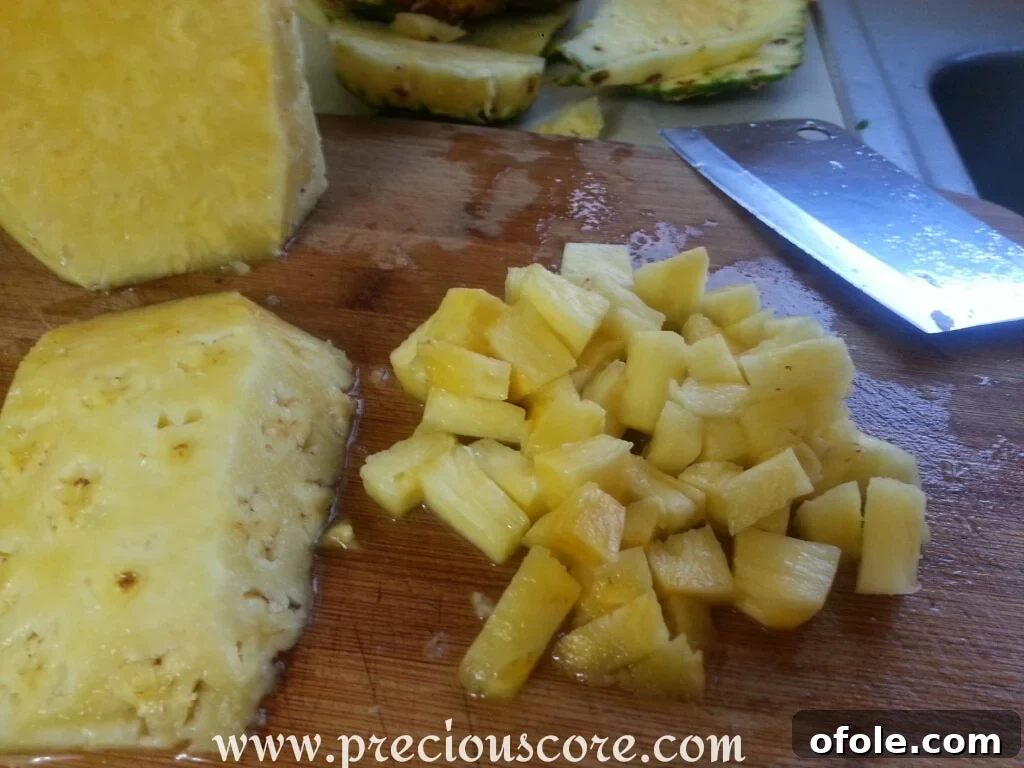 Vibrant Cameroonian Fruit Salad 2 Freshly cut pineapple chunks in a large mixing bowl, ready for other fruits