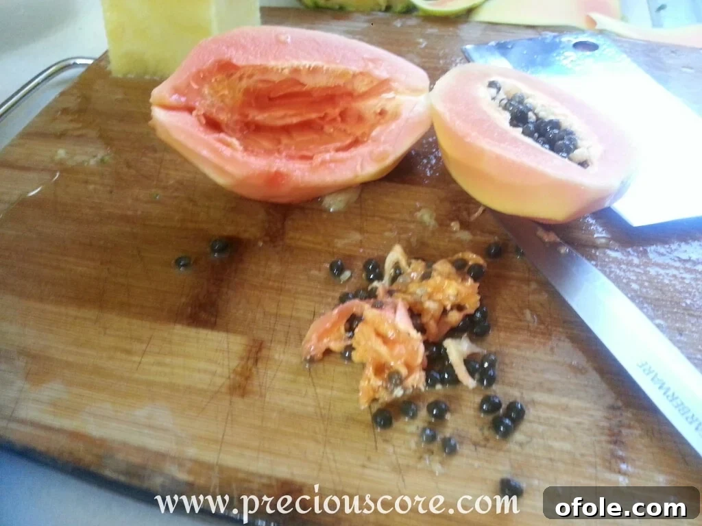 Vibrant Cameroonian Fruit Salad 4 A peeled pawpaw (papaya) cut in half lengthwise, revealing the black seeds
