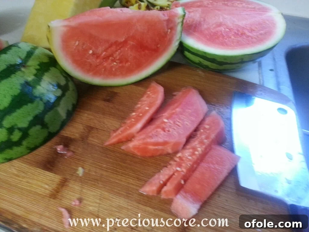 Vibrant Cameroonian Fruit Salad 8 A large piece of watermelon, with its rind separated from the red flesh, ready for chopping
