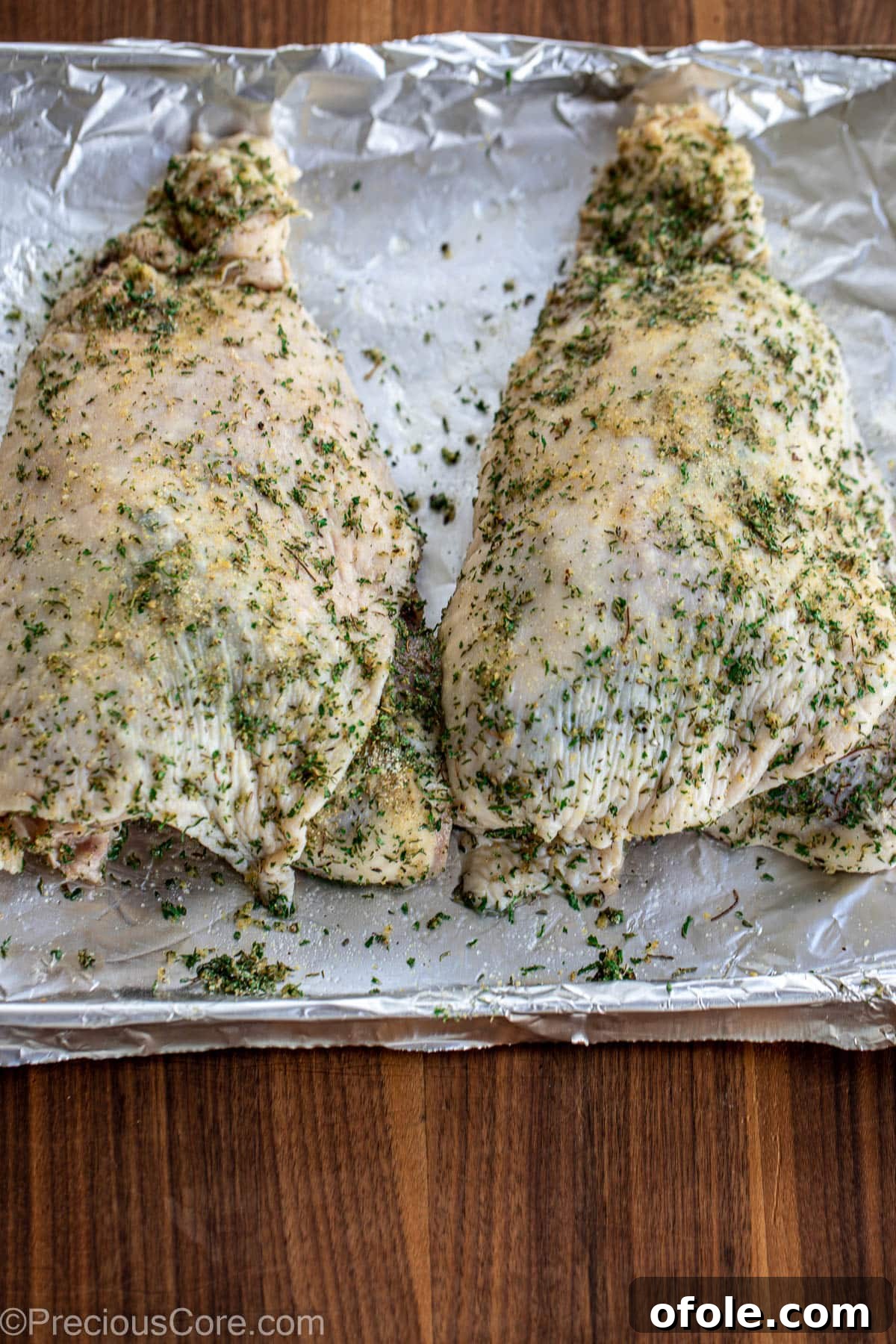 Raw turkey thighs coated in a rich blend of seasonings, ready for roasting.