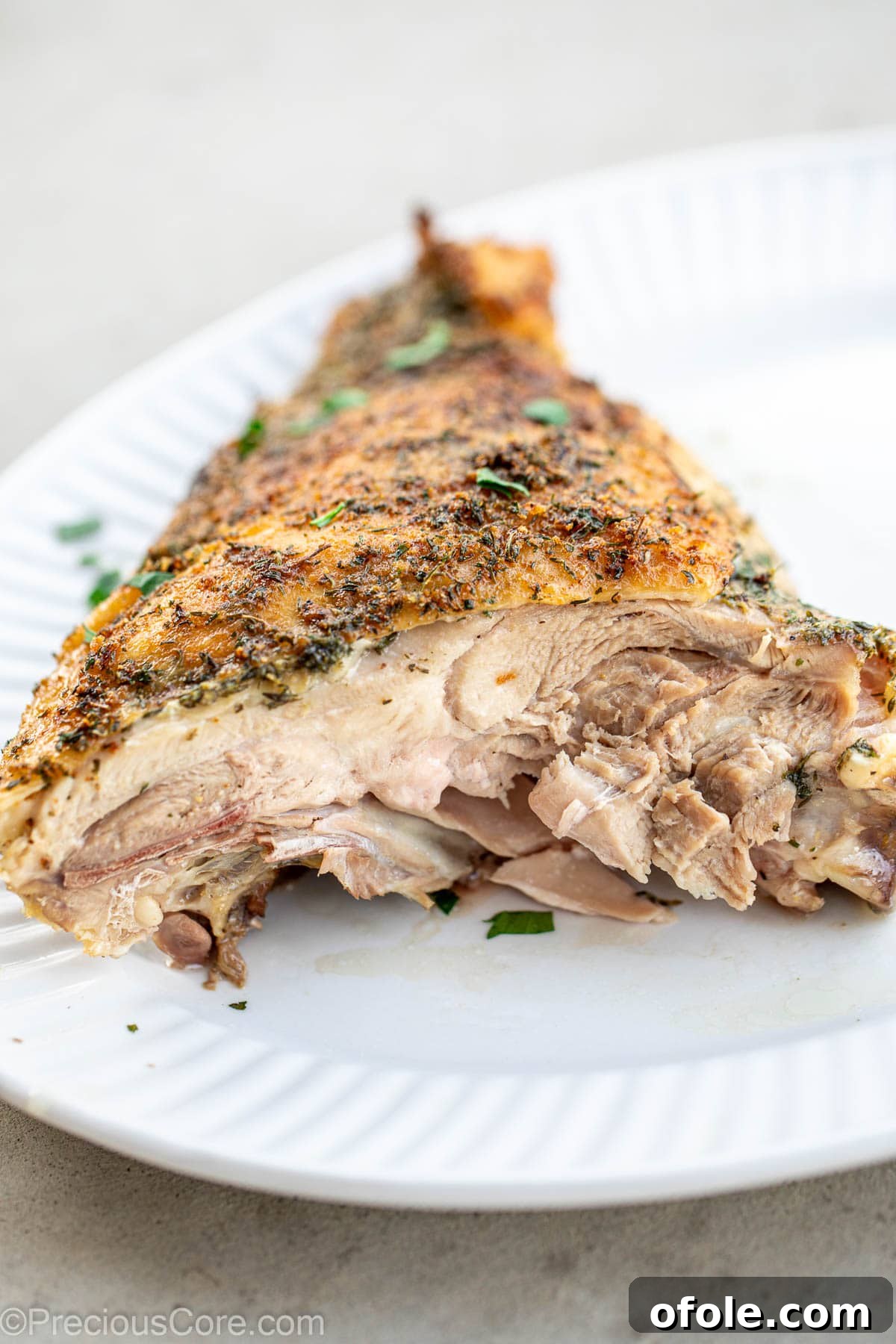 A perfectly cooked turkey thigh, sliced to reveal its tender, juicy interior.
