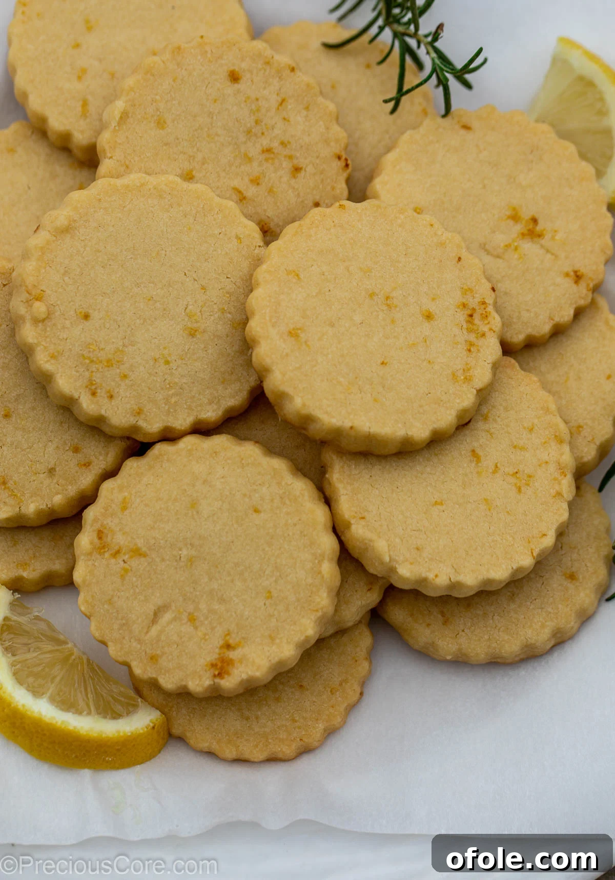 Freshly baked Lemon Shortbread Cookies artfully arranged on parchment paper.