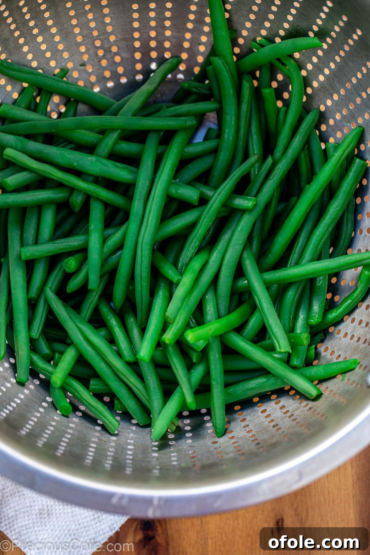 Runner beans being drained in a colander.