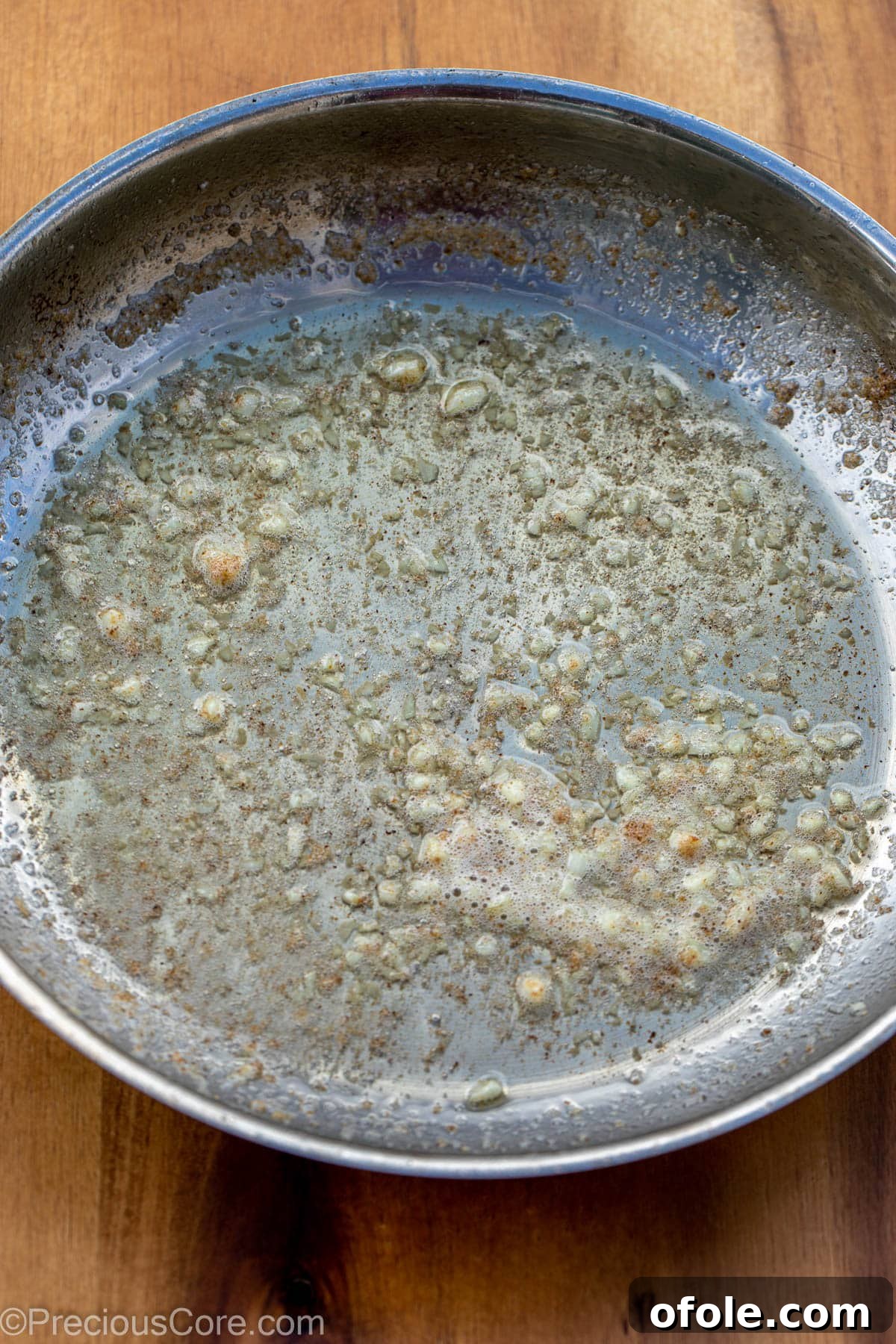 Minced garlic and melted butter in a hot skillet, gently sizzling.
