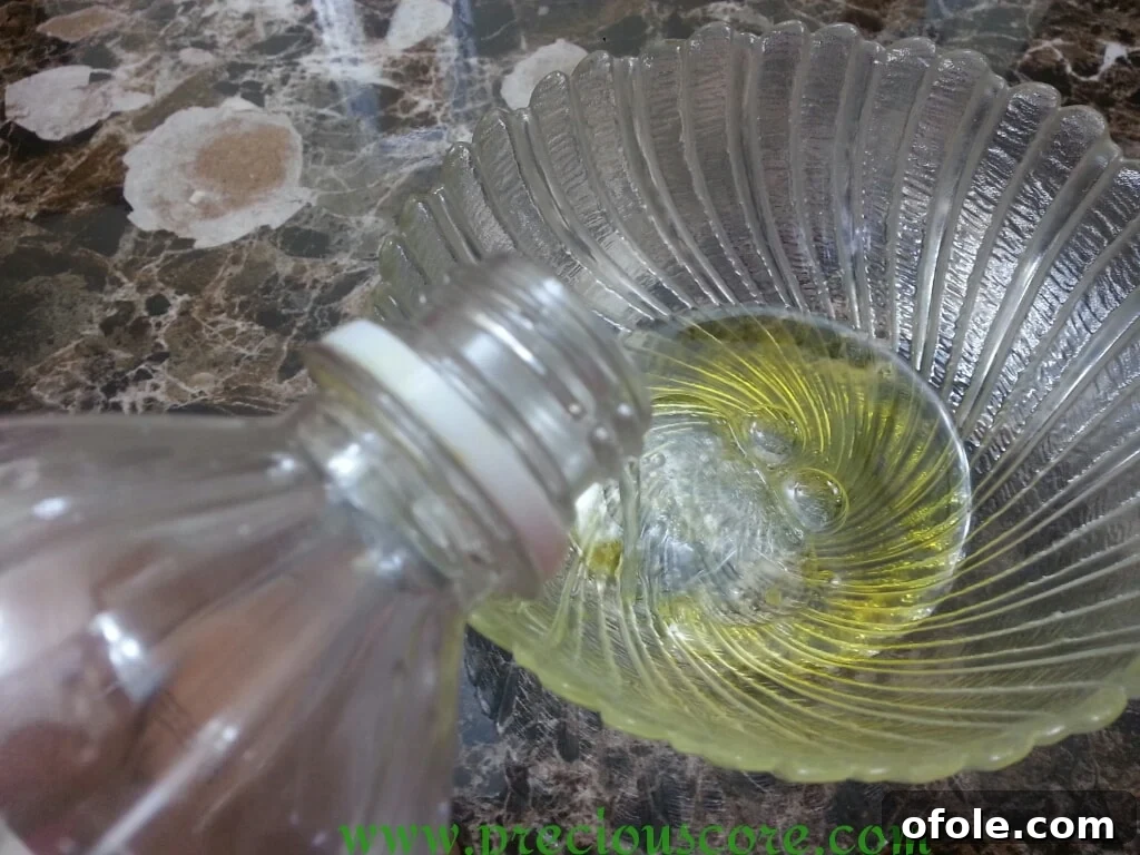 White vinegar being added to olive oil in a bowl