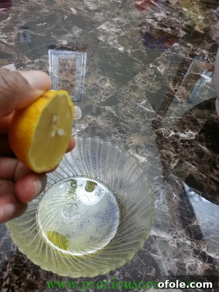 Fresh lemon juice being squeezed into the dressing bowl