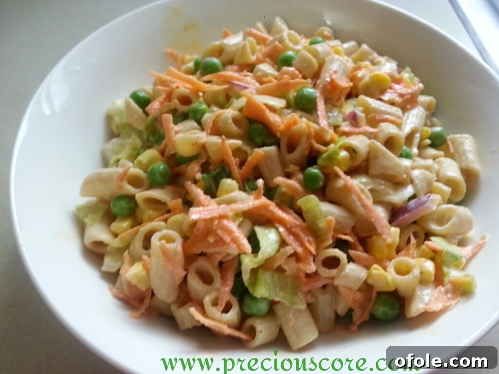 Close-up of freshly prepared pasta salad with vegetables and a creamy dressing