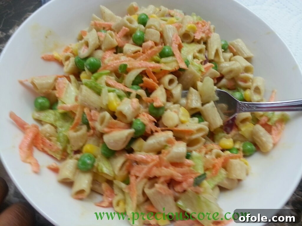 A serving of healthy whole wheat pasta salad on a plate with a fork