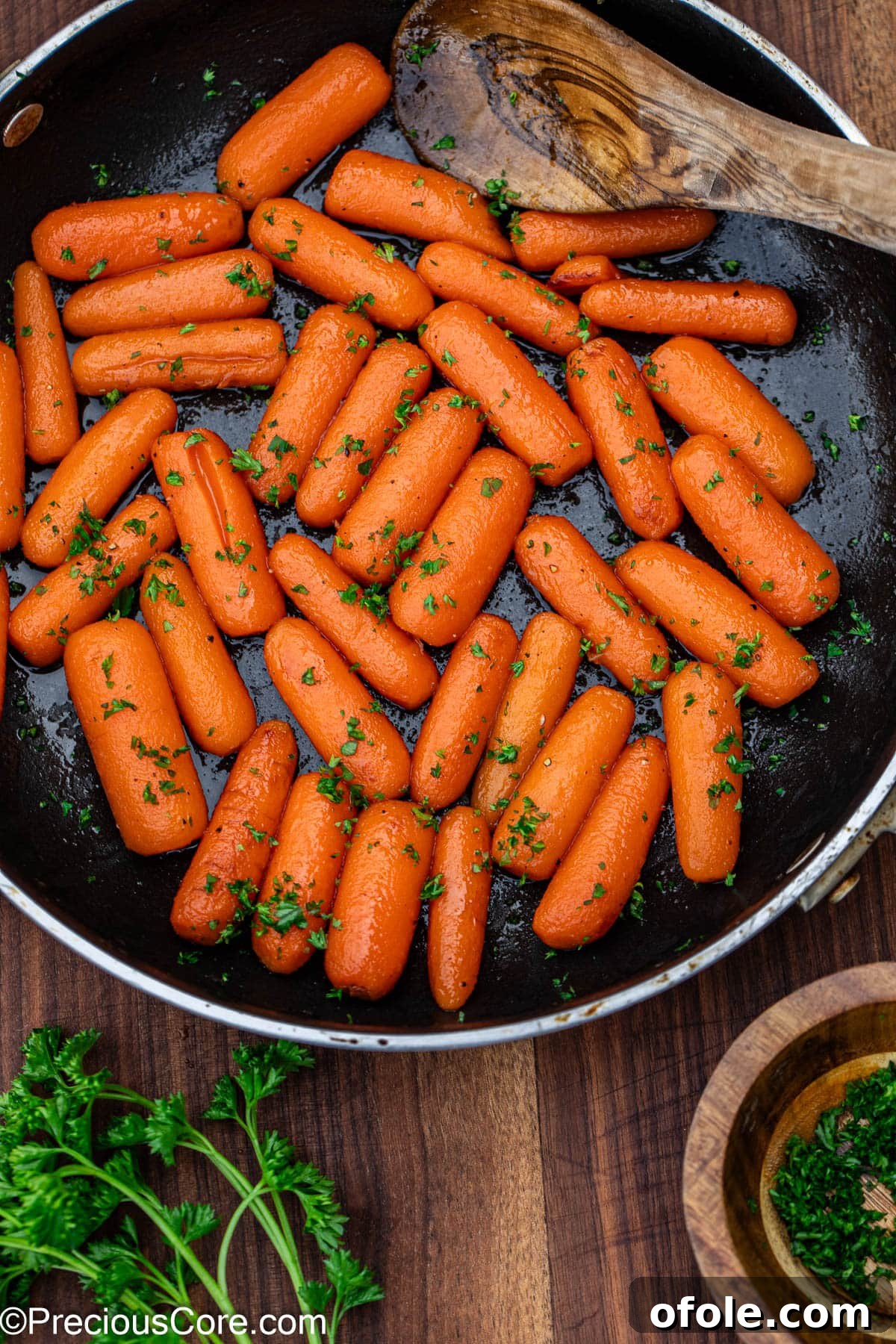Glazed carrots garnished generously with fresh parsley, highlighting their vibrant color.