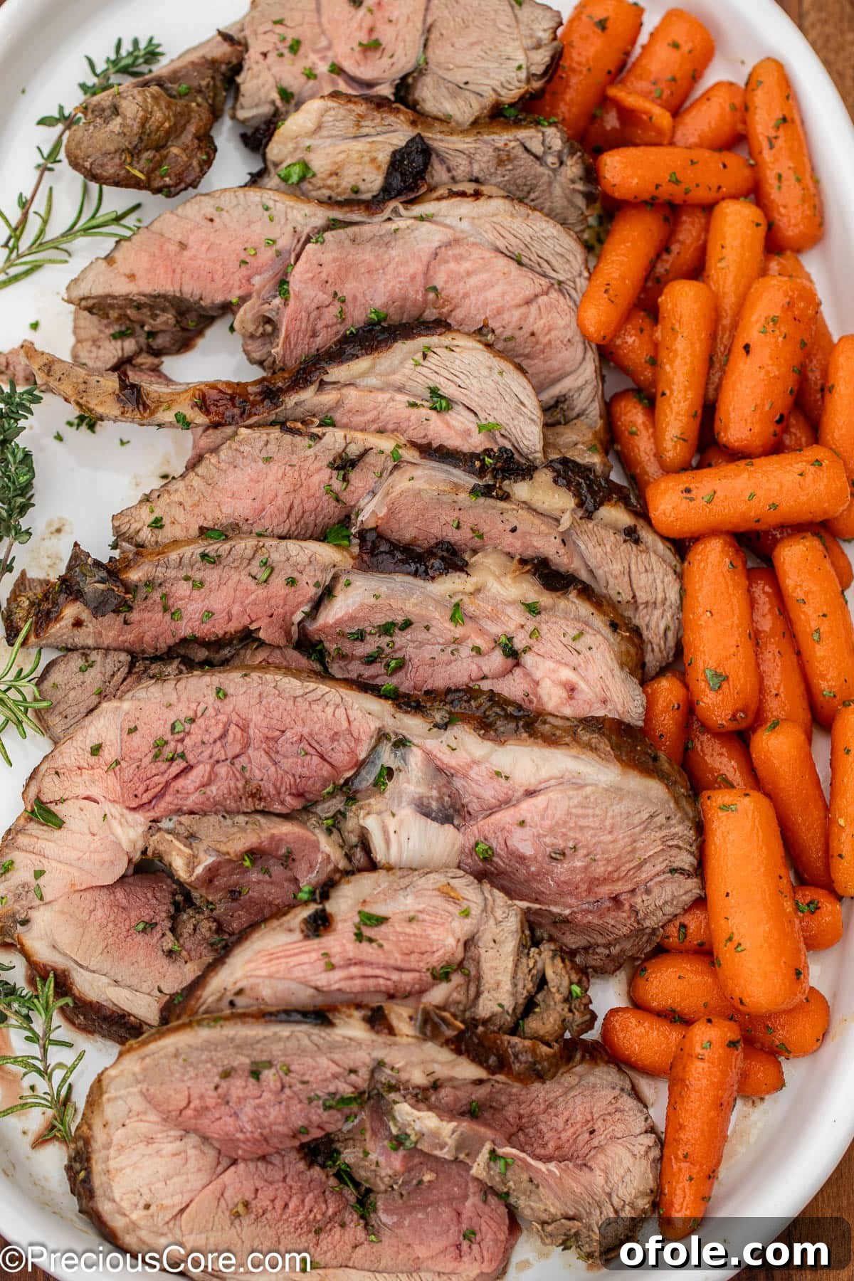 A delicious roasted lamb dish served on a platter with a generous side of glazed carrots.