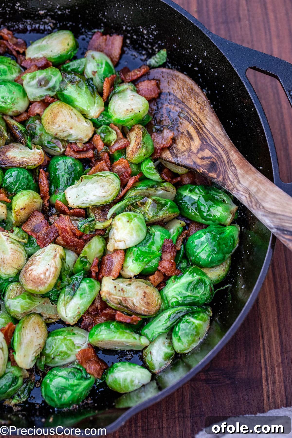 Cooked bacon with Brussels sprouts mixed together in a skillet, showcasing a perfect blend of ingredients.