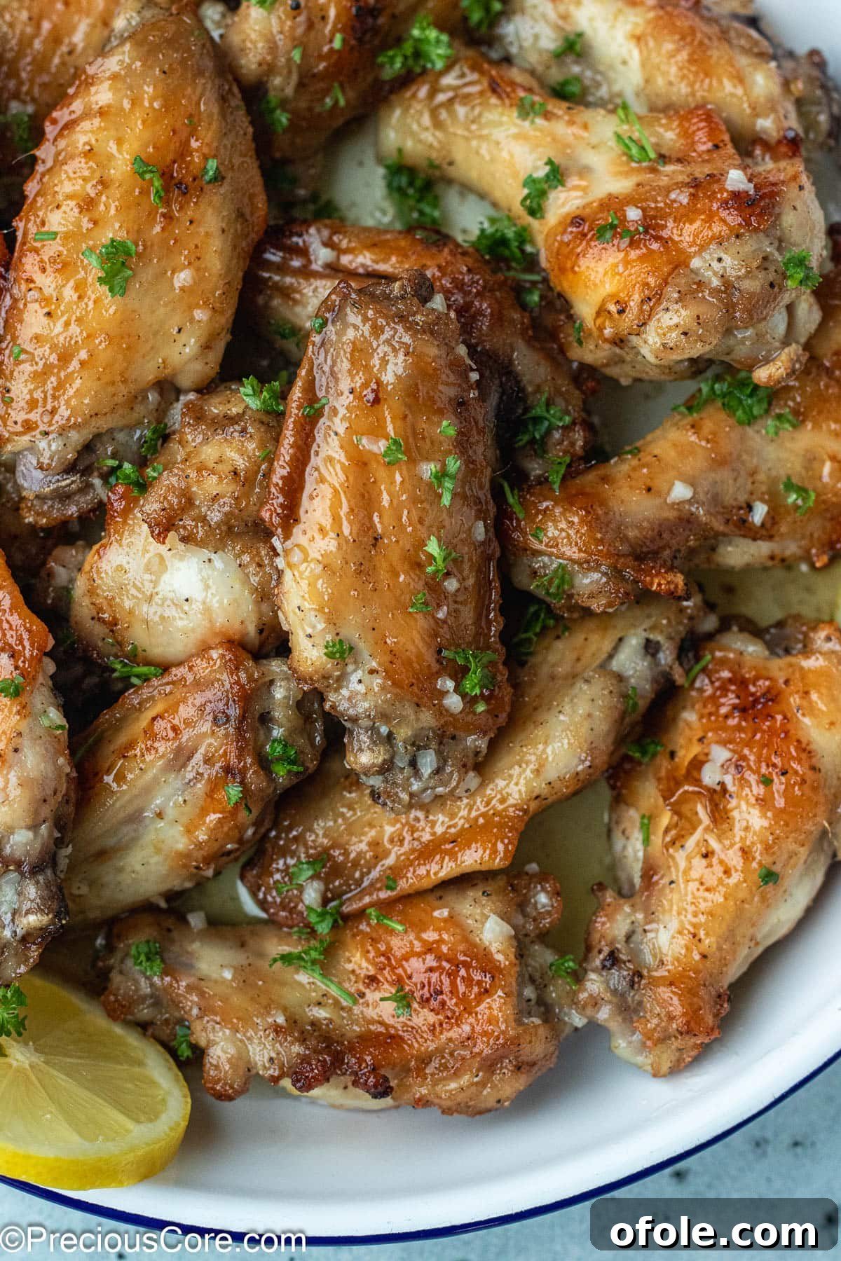 Garlic Gold Wings 3 A bowl brimming with perfectly cooked chicken wings, nestled in a pool of golden garlic butter sauce.