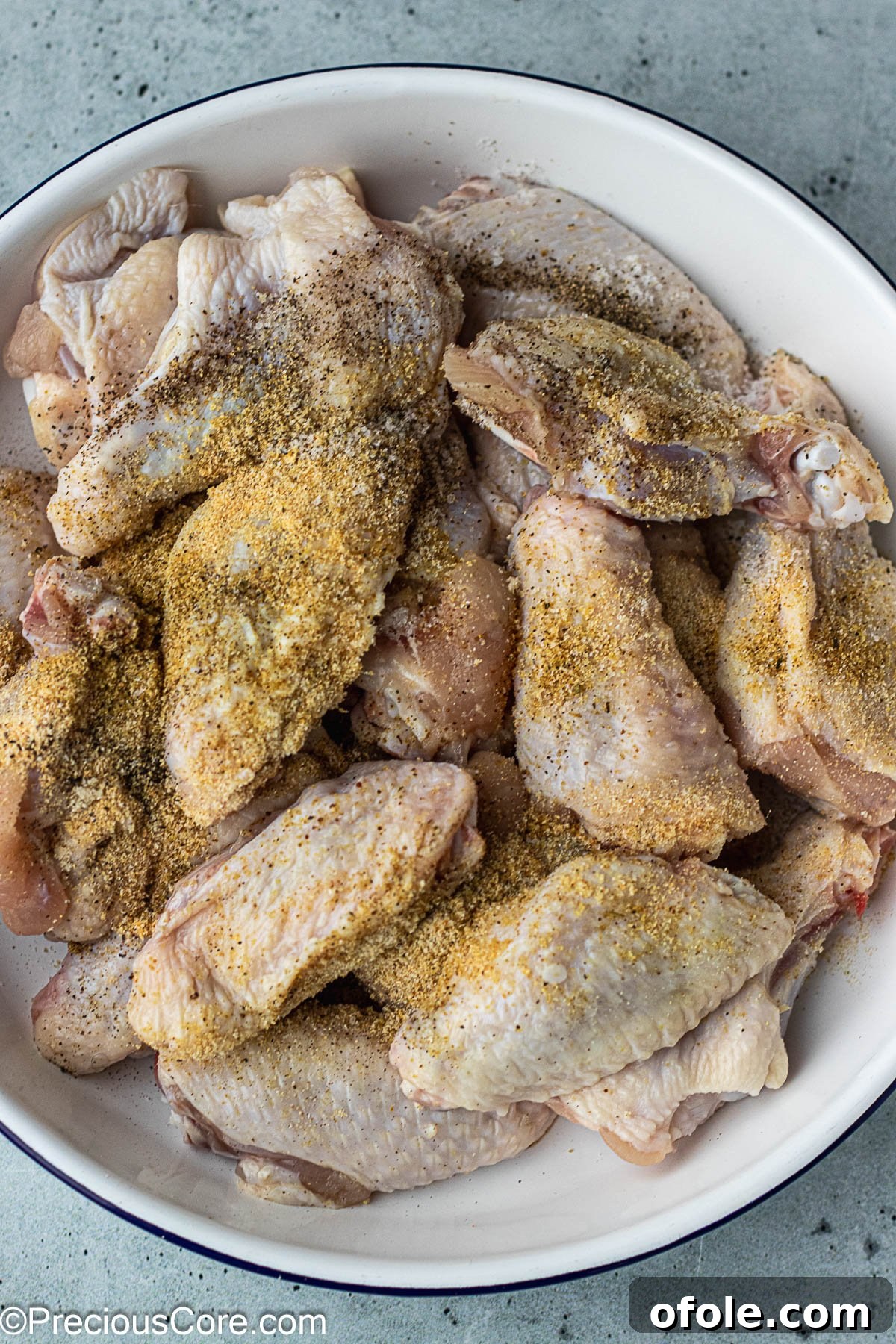 Garlic Gold Wings 6 Chicken wings in a white bowl, generously coated with a savory seasoning powder blend.