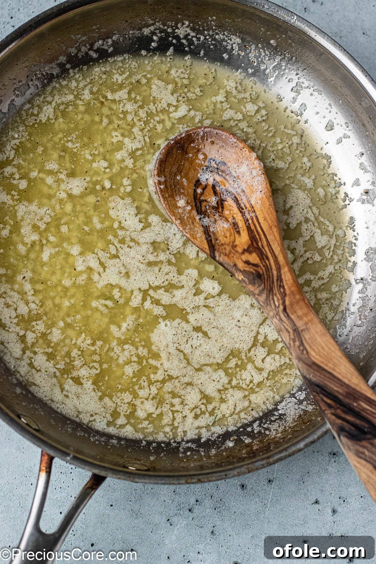 Garlic Gold Wings 8 Close-up of a stainless steel skillet filled with bubbling garlic butter sauce.