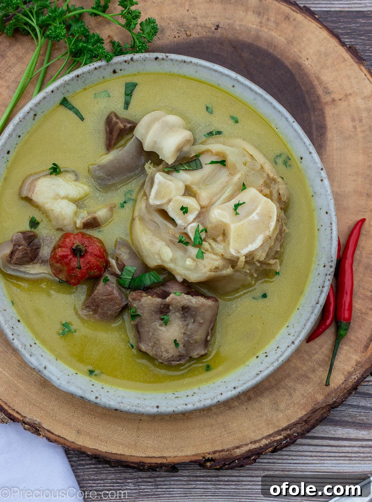 Authentic Cameroonian Pepper Soup 2 Bowl of pepper soup sitting on a round platter.