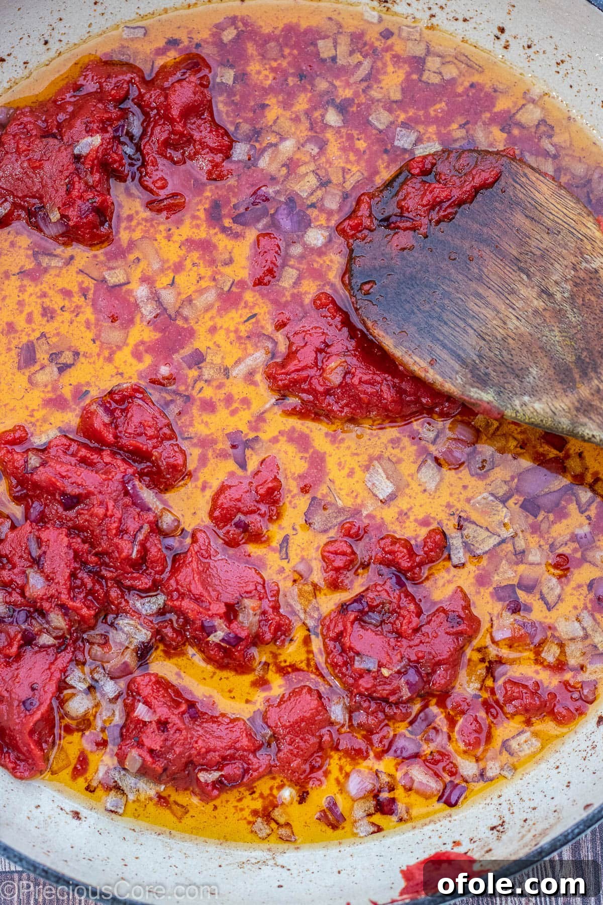 Soulful Nigerian Beef Stew 8 Diced onions and tomato paste cooking in oil, forming the aromatic base of the stew.