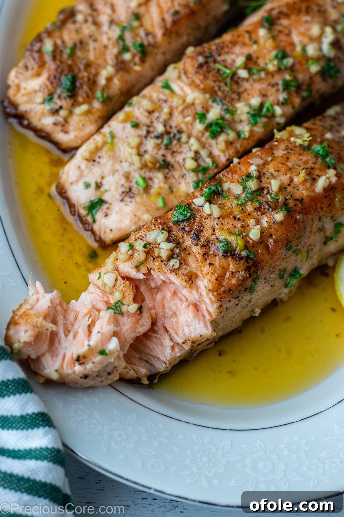 A perfectly flaky piece of lemon butter salmon on a platter, showcasing its moist and juicy interior.