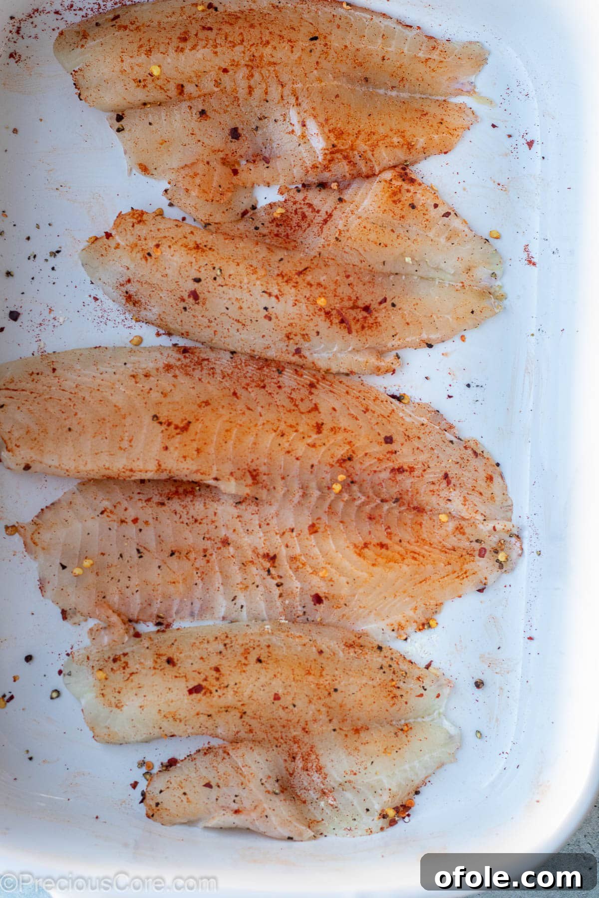 Garlic Butter Infused Tilapia 5 Seasoned tilapia fillets waiting in a bowl, perfectly prepped.