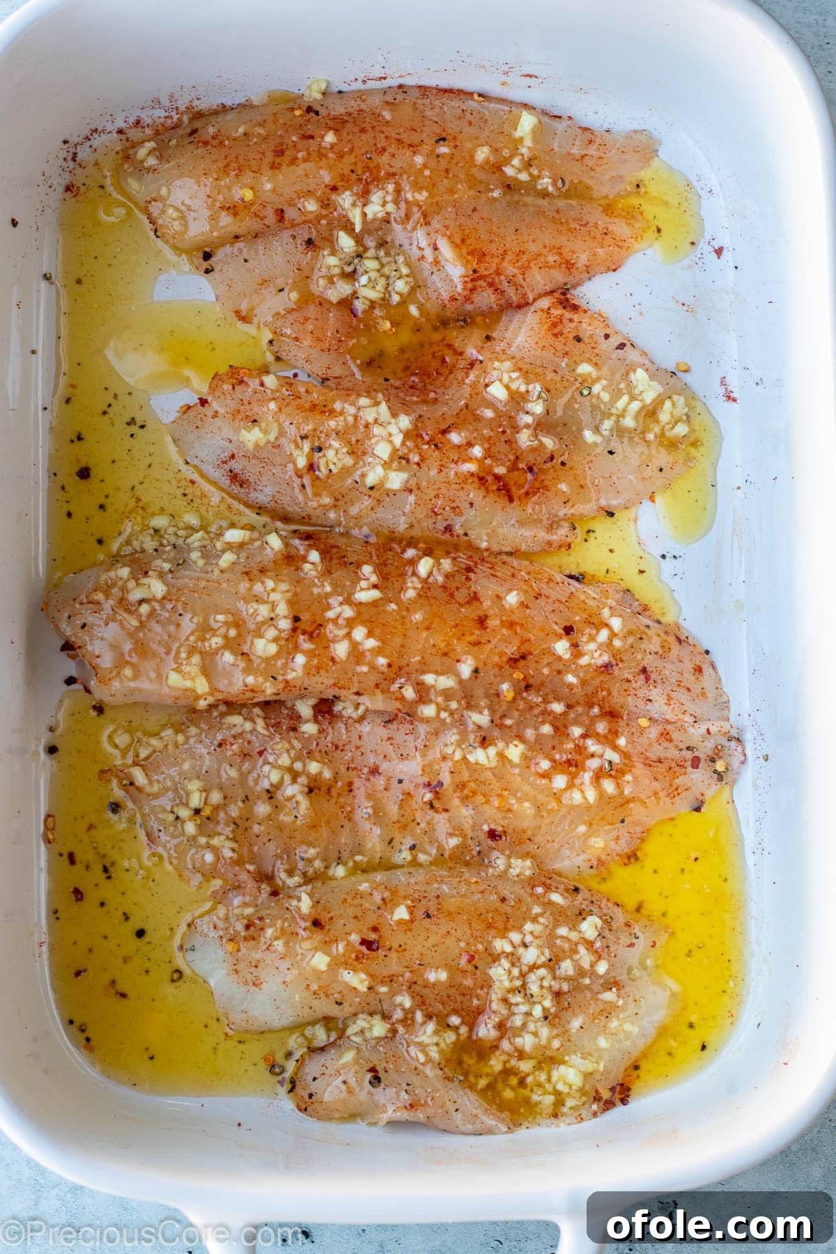 Garlic Butter Infused Tilapia 7 Raw fish fillets beautifully covered with the vibrant garlic butter sauce.