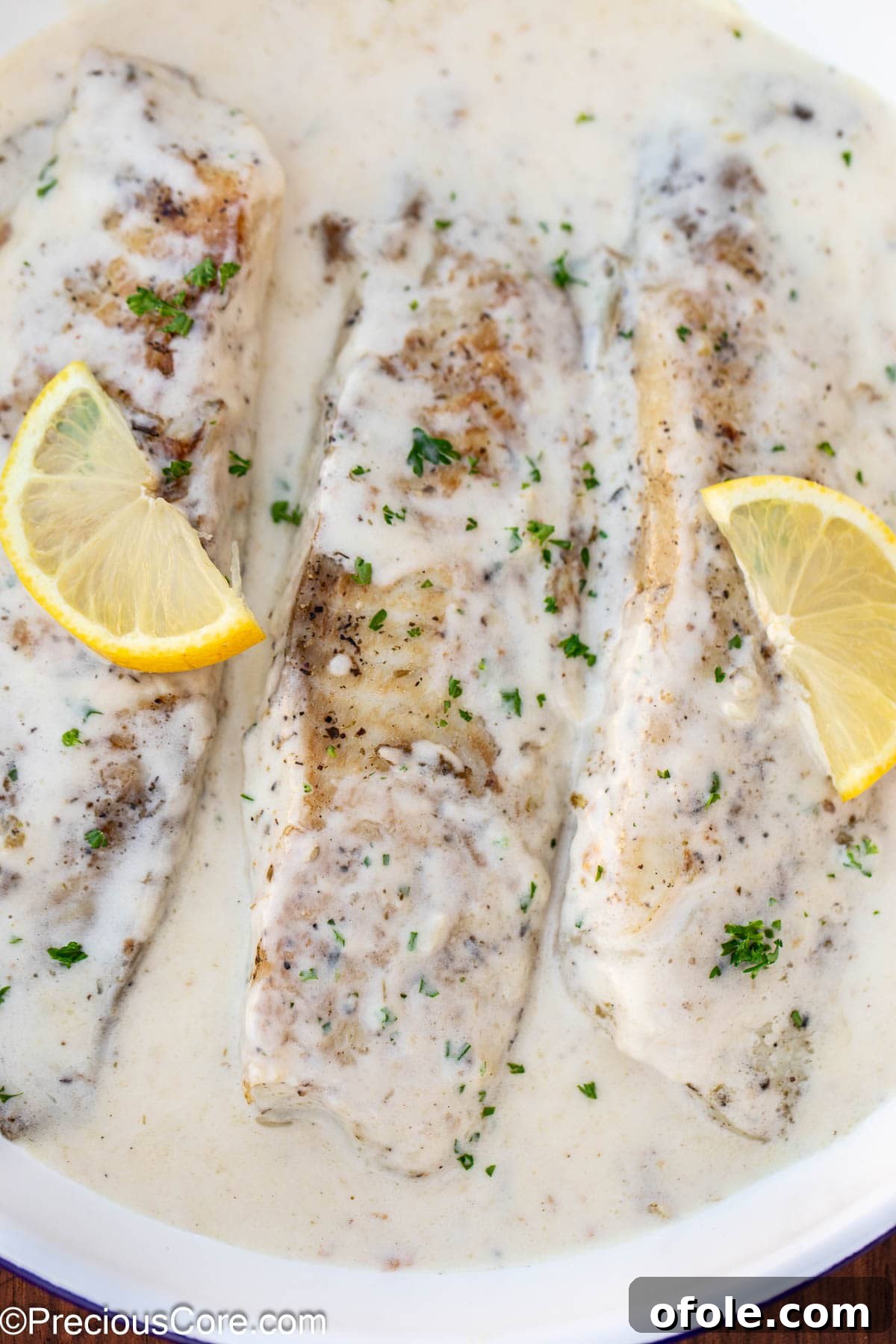 Velvety White Fish 2 Cooked fish fillets in a skillet with a luscious white lemon-garlic cream sauce, ready to serve.