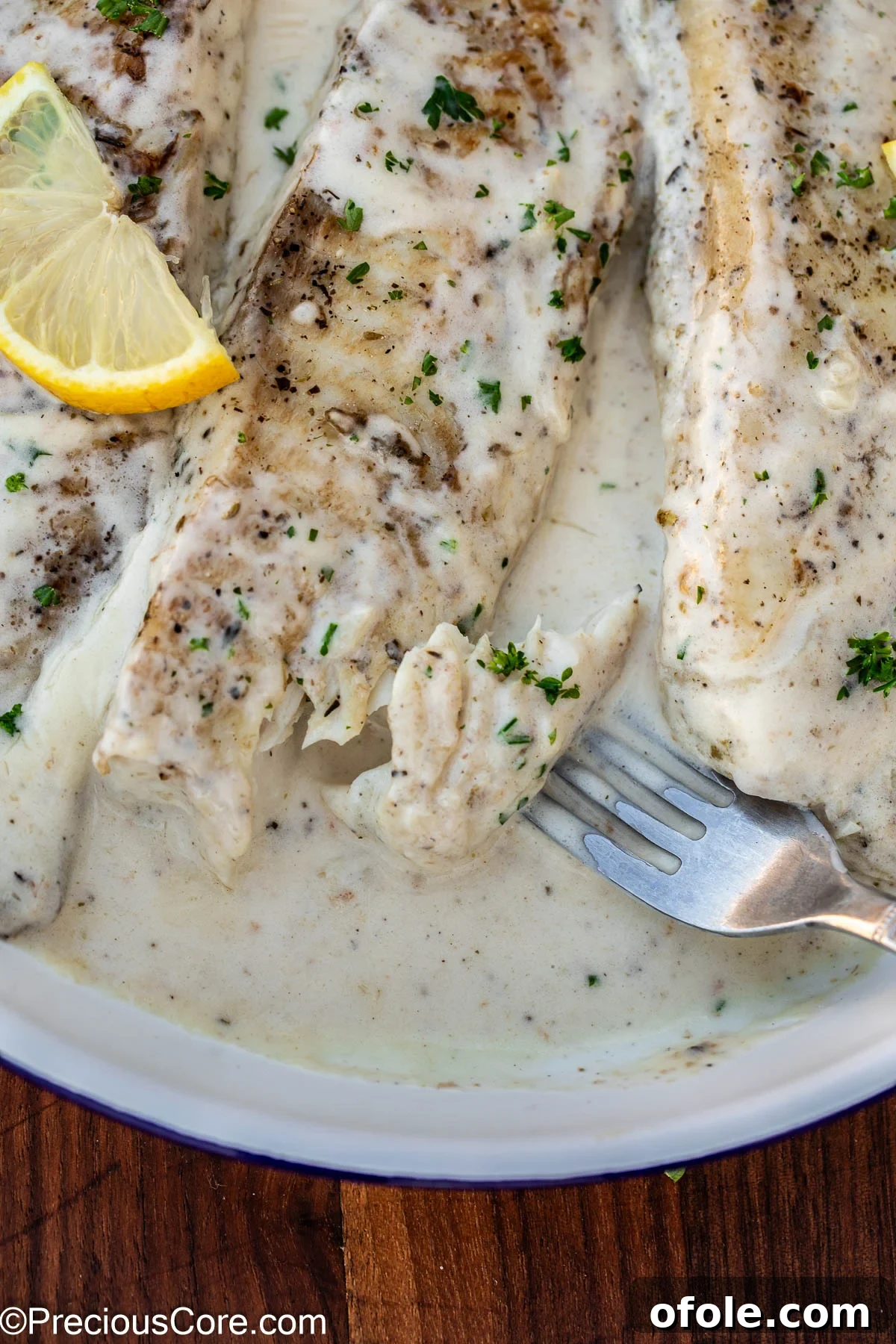 Velvety White Fish 13 A fork testing the tenderness and flakiness of cooked fish in white sauce, demonstrating its perfect readiness.