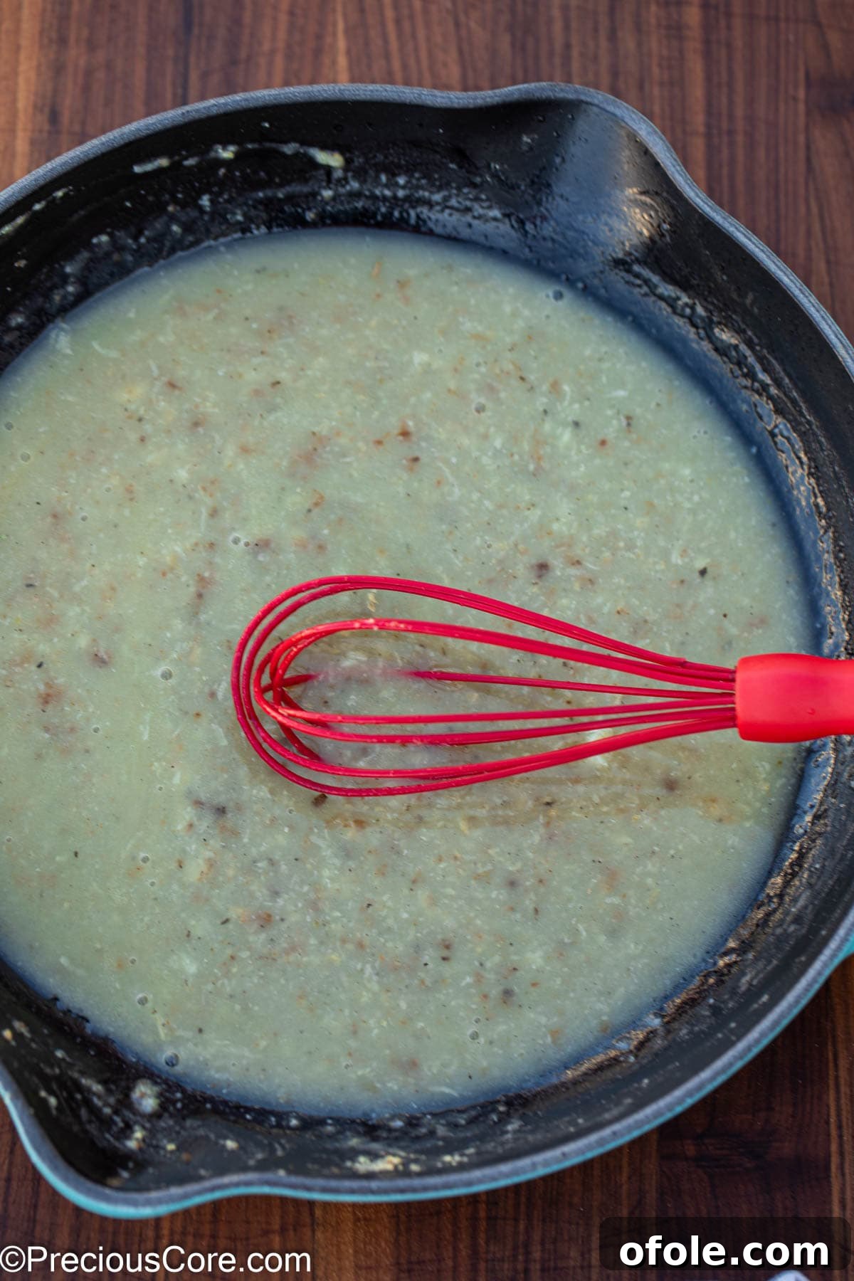 Velvety White Fish 8 A whisk smoothly combining flour and chicken stock in the skillet, starting the thickening process of the white sauce.