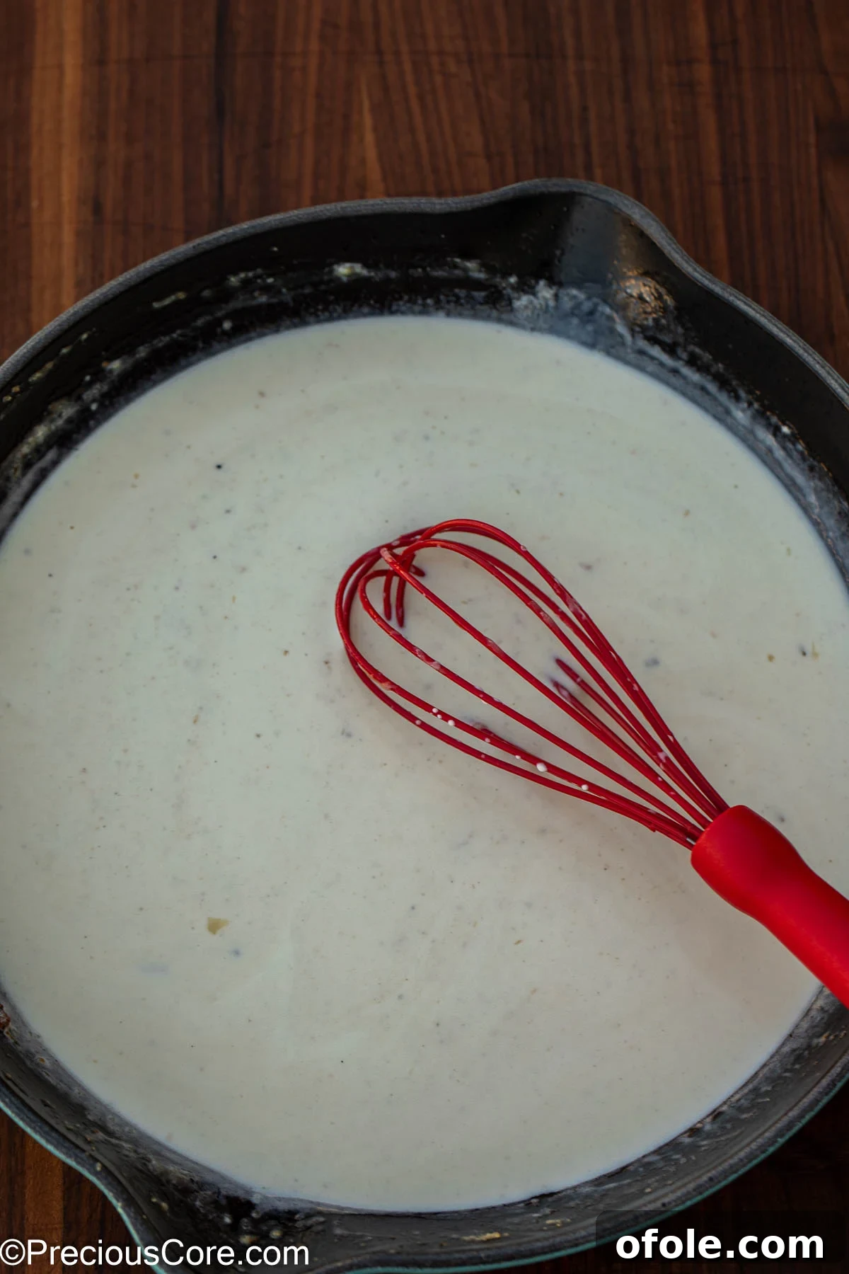 Velvety White Fish 9 The rich white sauce gently simmering in the pan, achieving its desired creamy and glossy texture.