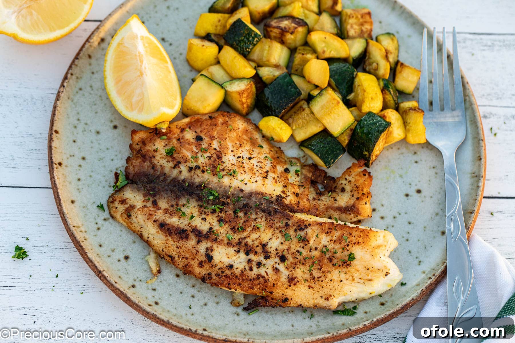 A landscape orientation image of lemon pepper tilapia served with a side of colorful, sautéed vegetables, perfect for a healthy meal.