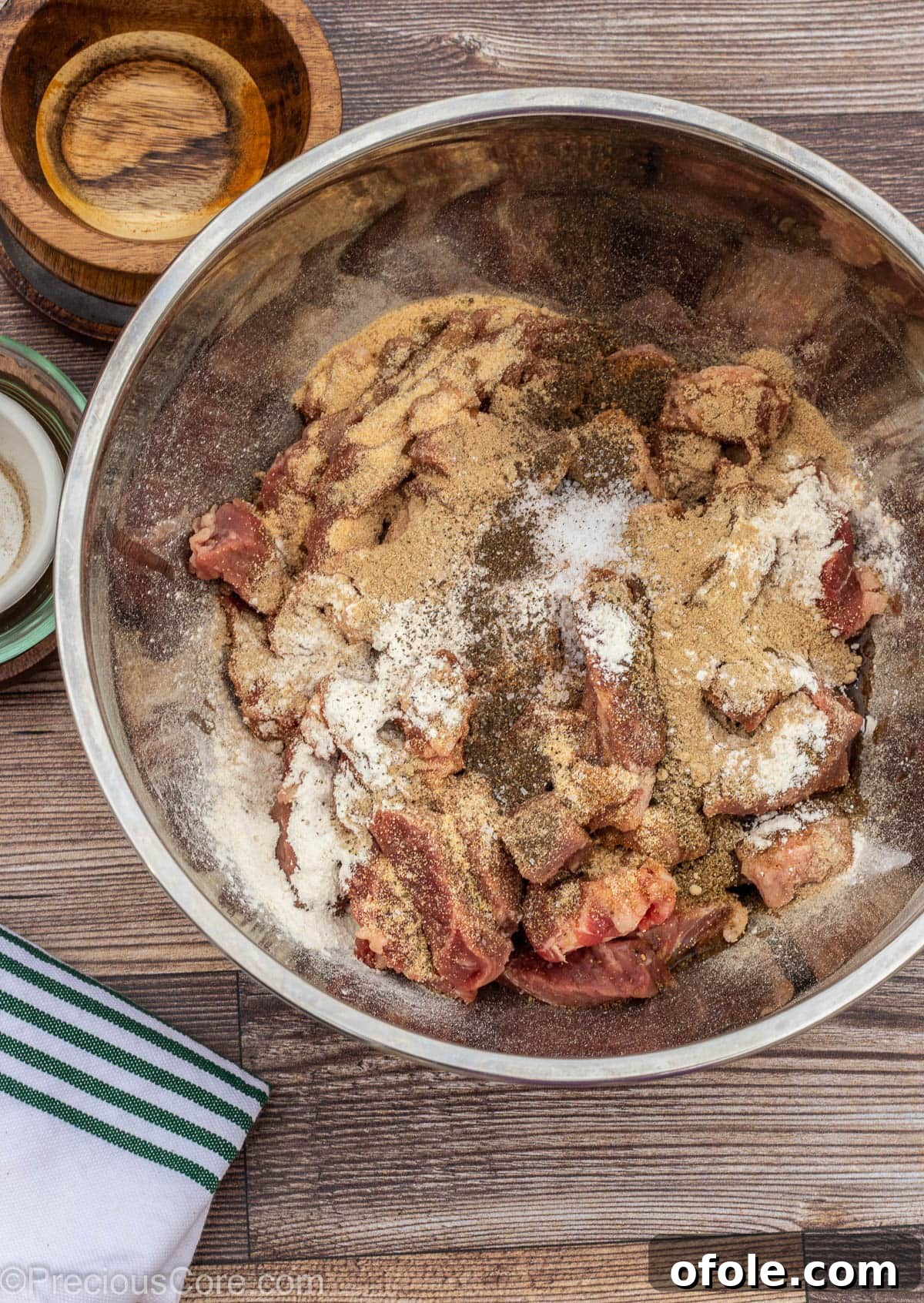 Cameroonian Soya Snack 5 Thinly sliced beef in a bowl, generously topped with olive oil and a vibrant blend of dry spices.