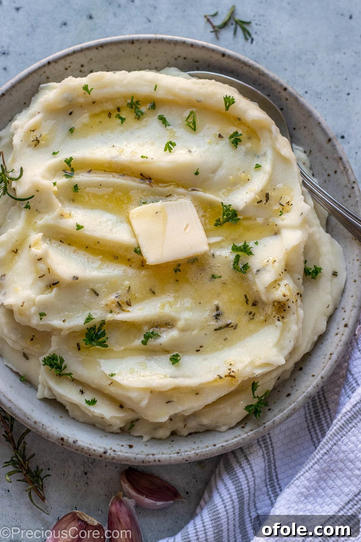 Aromatic Rosemary Garlic Mash 2 Rosemary Garlic Mashed Potatoes in a bowl topped with melted butter and parsley.