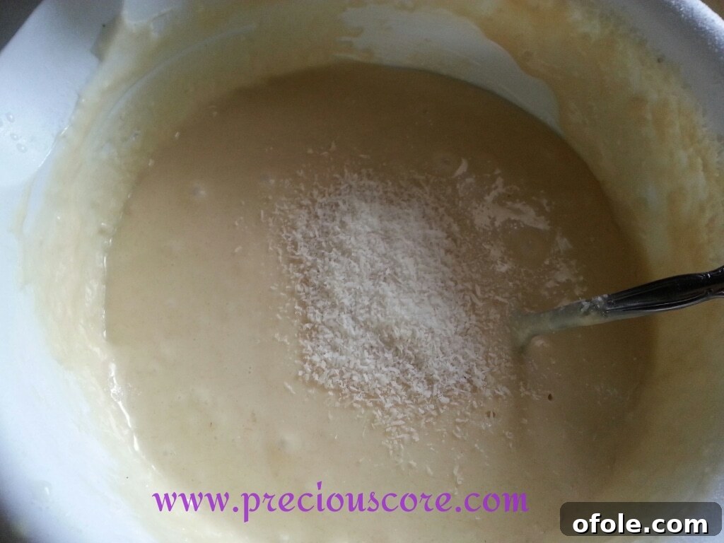 Thick pancake batter with visible shredded coconut mixed throughout, ready for cooking.