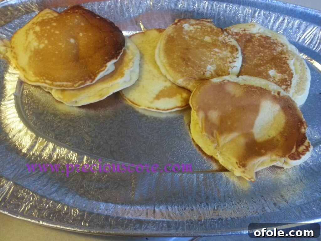 A tall stack of golden brown, perfectly cooked coconut pancakes, ready for breakfast.