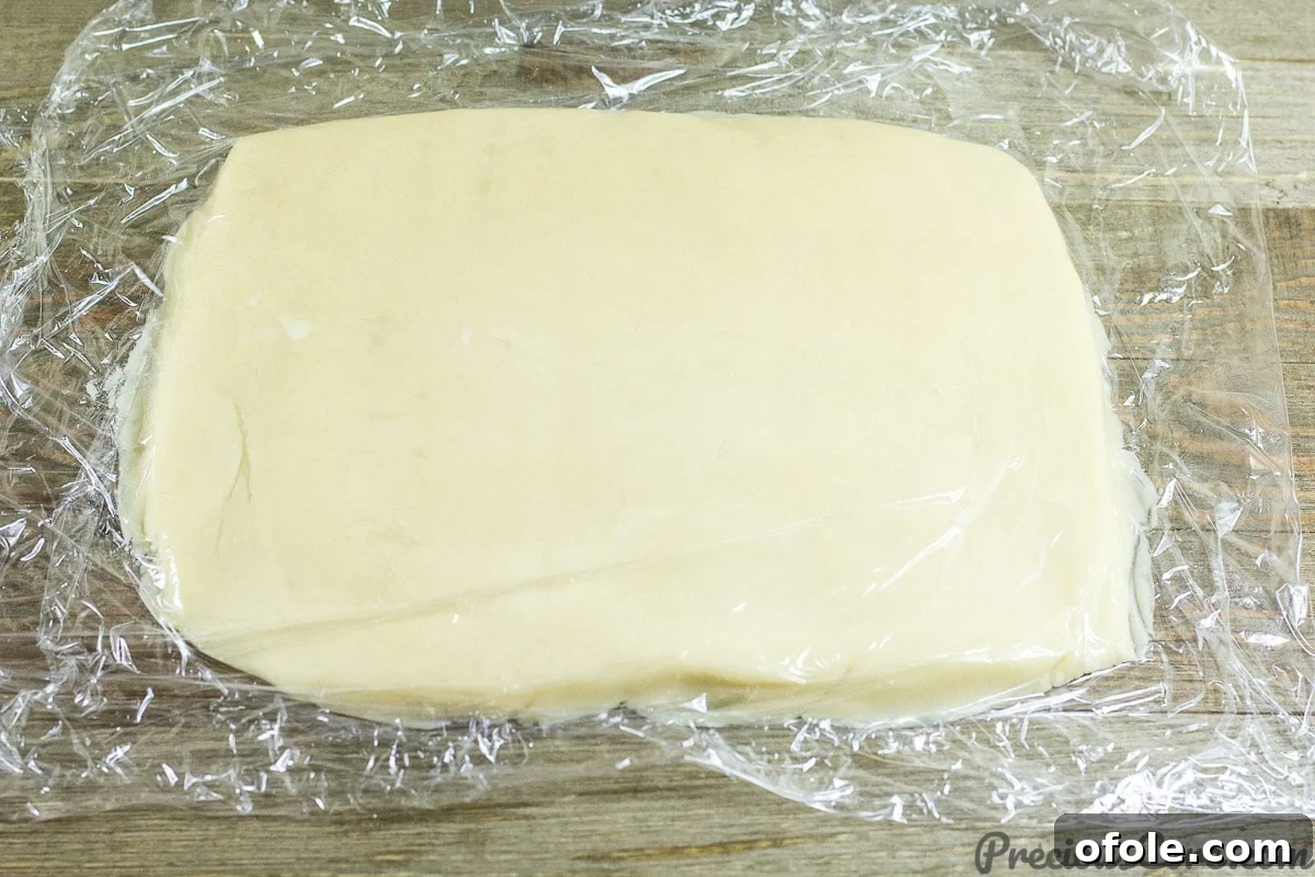 Perfect Buttery Shortbread From Scratch 11 Shortbread dough wrapped in plastic wrap and pressed into a rectangular shape, prepared for chilling.