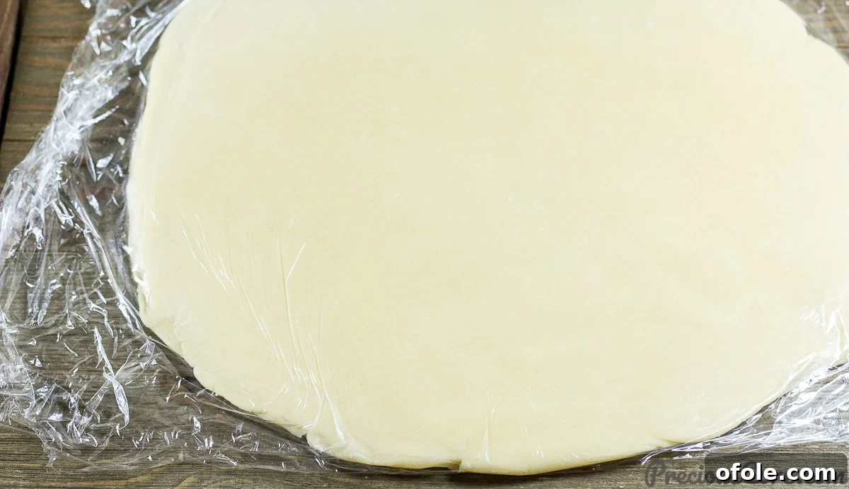 Perfect Buttery Shortbread From Scratch 12 Chilled shortbread dough, rolled out evenly between two sheets of plastic wrap, achieving the perfect thickness for cutting.