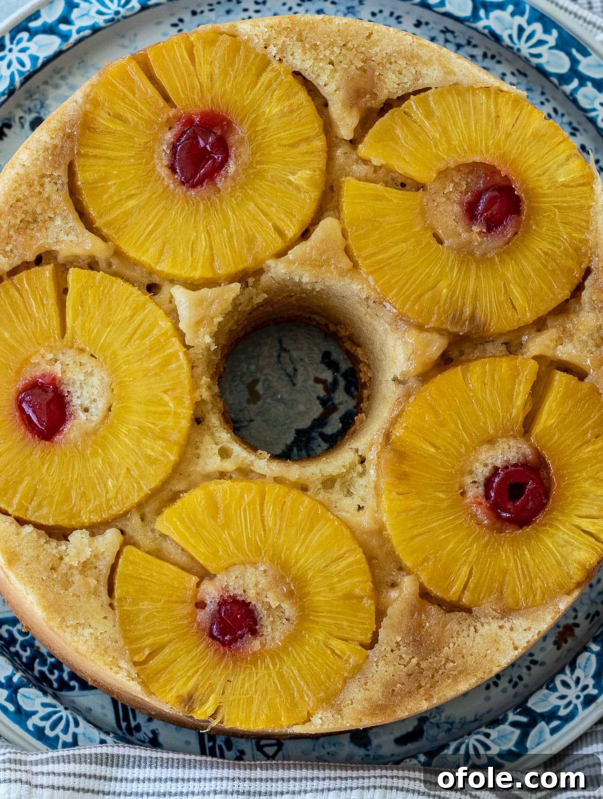 A perfectly round Pineapple Upside Down Pound Cake on a wire rack.