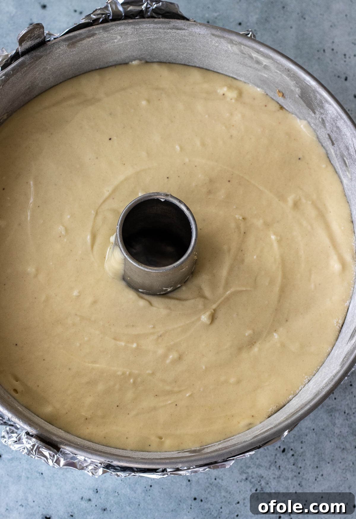 Rich pound cake batter smoothly poured into the prepared baking pan, ready for the oven.