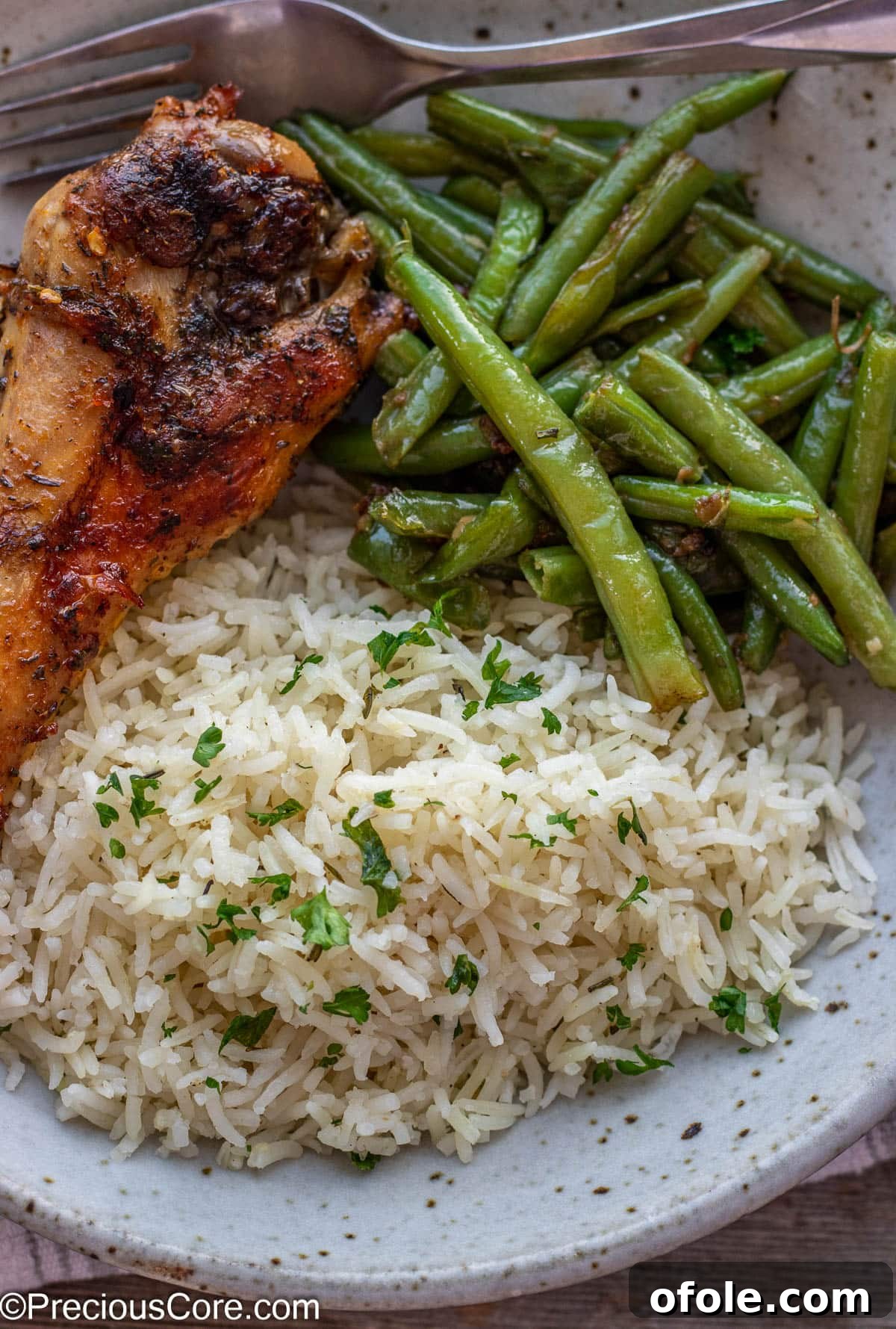 A beautifully composed meal featuring fluffy garlic herb rice, vibrant green beans, and roasted turkey, perfect for a hearty dinner.