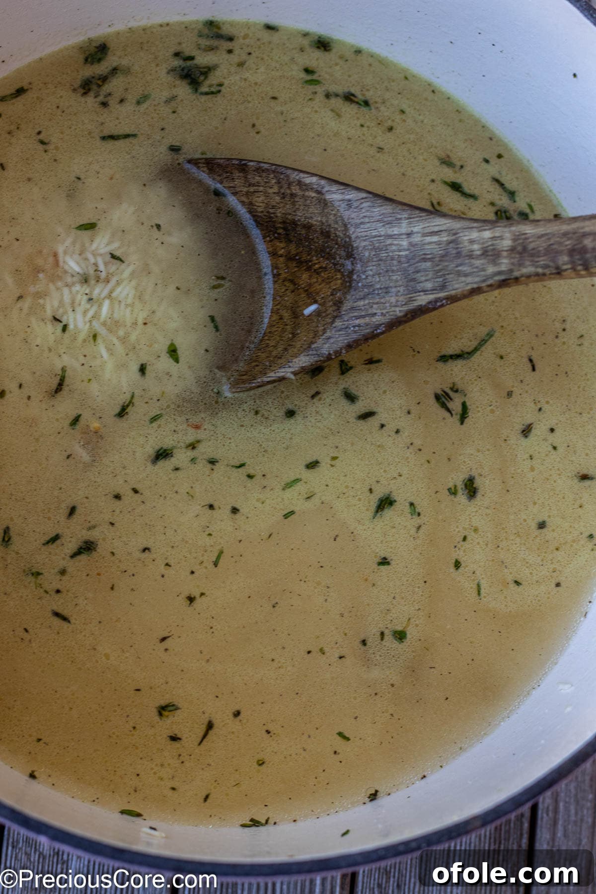 Water, seasoning, and toasted rice combined in a pot, now covered and simmering to cook perfectly.