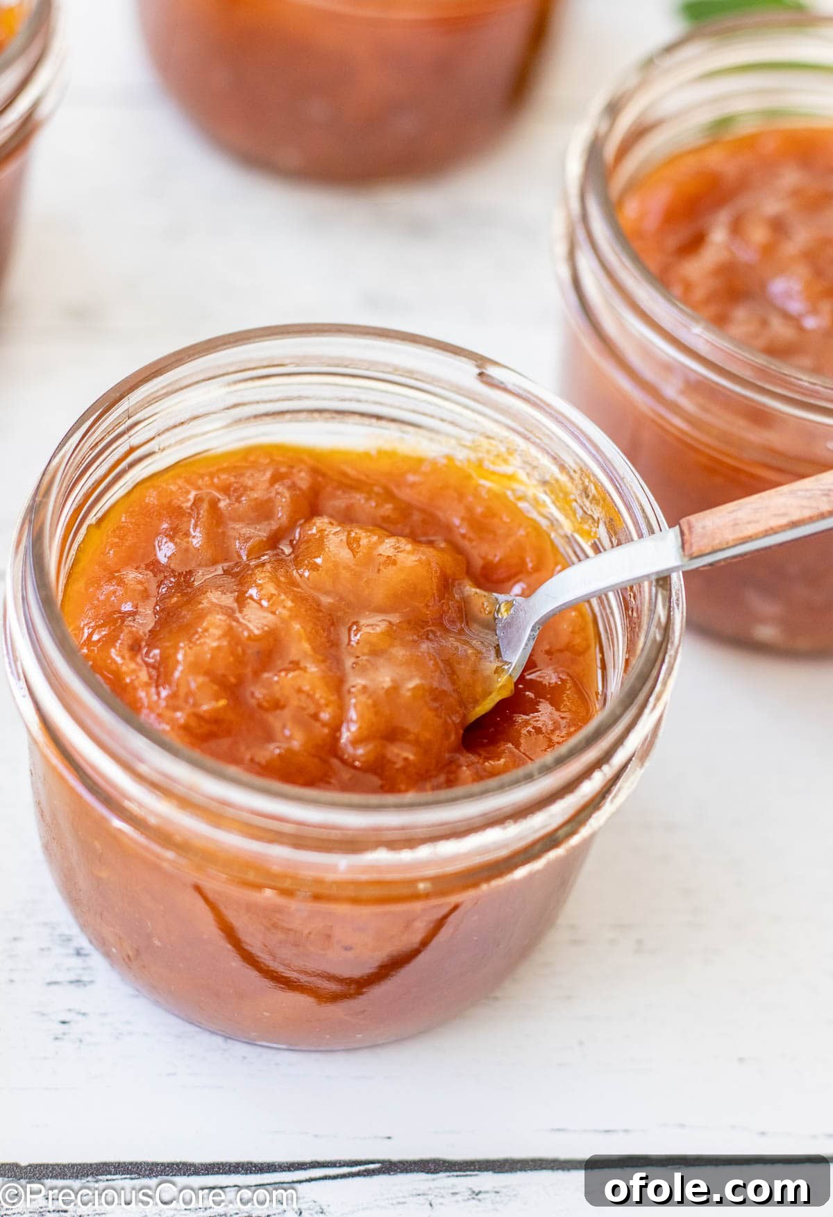 A beautiful glass jar filled with golden homemade apricot preserves, ready for storage or gifting.