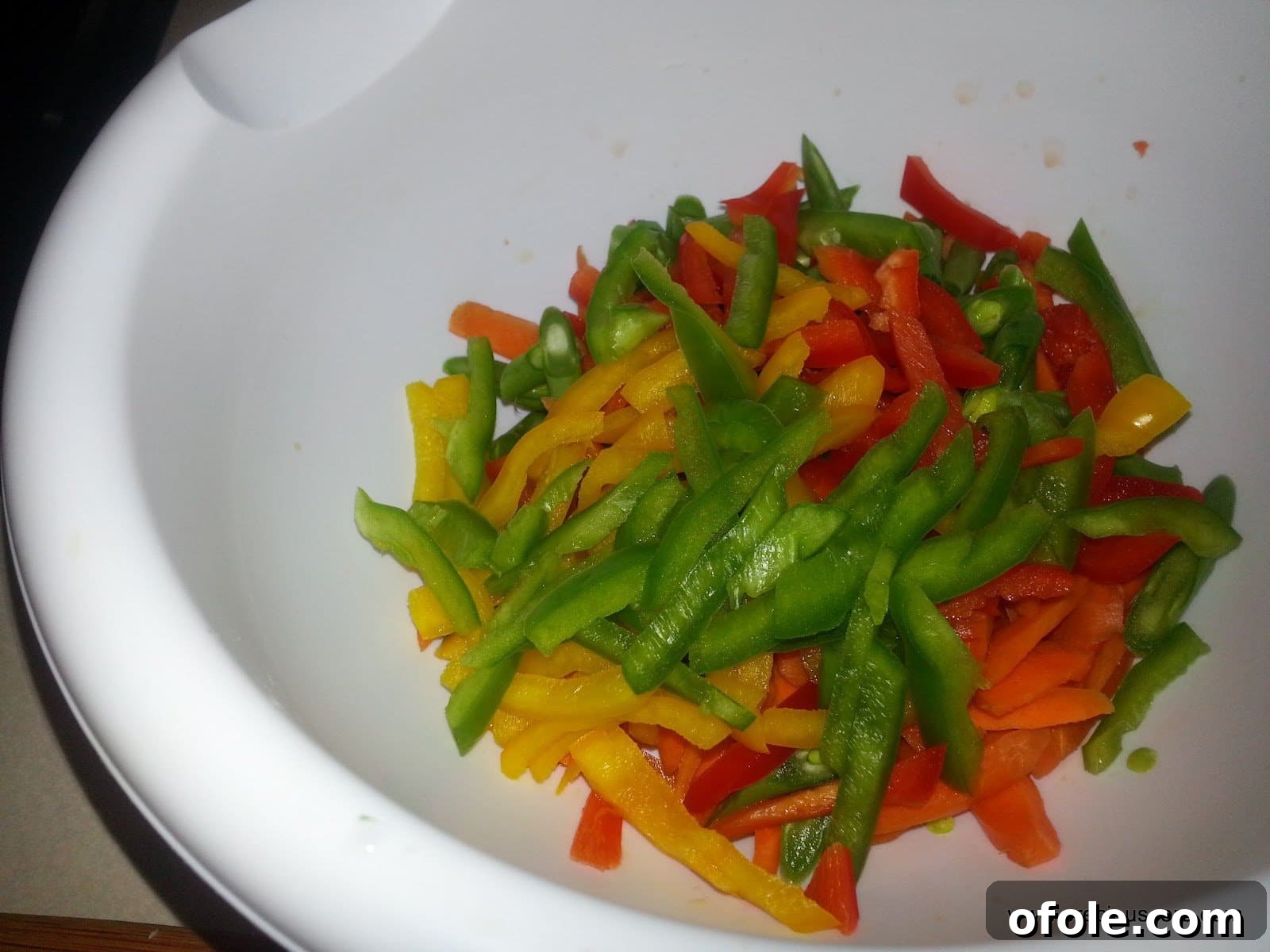 Assorted chopped vegetables including bright carrots, crisp green beans, and colorful bell peppers, meticulously prepared for the stir-fry.