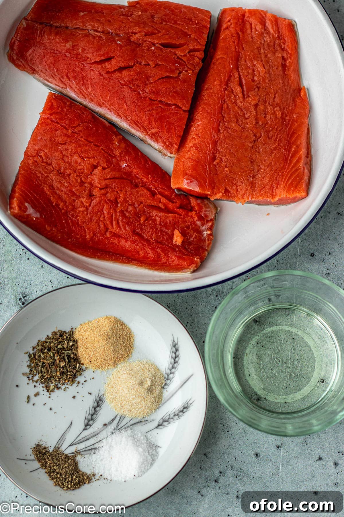 Irresistible Salmon Bites 4 Fresh salmon fillet, olive oil, and a selection of seasonings on a wooden board.